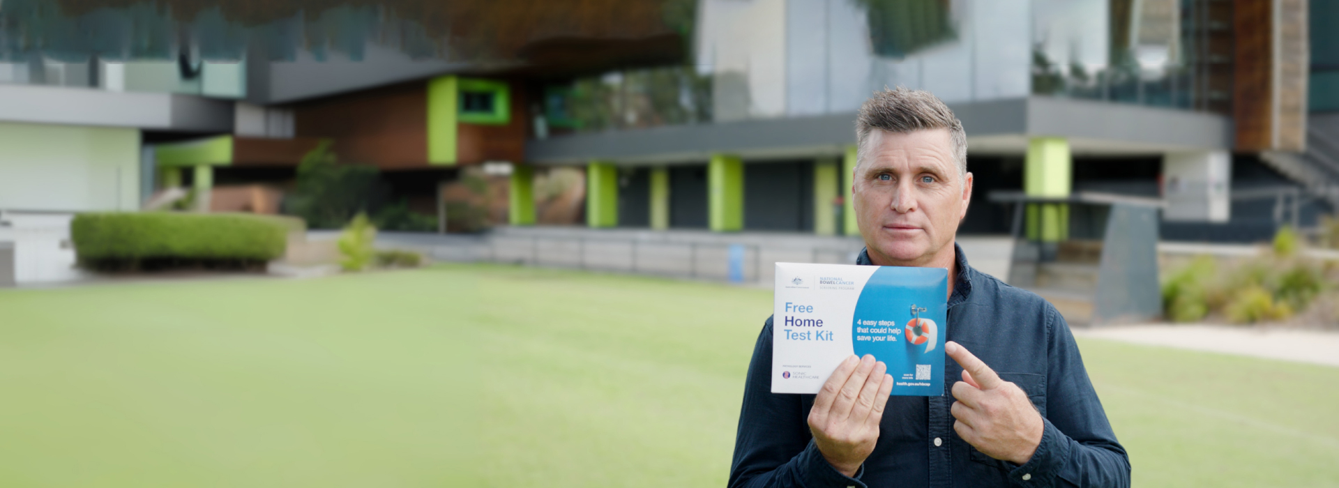 Man pointing at home bowel testing kit