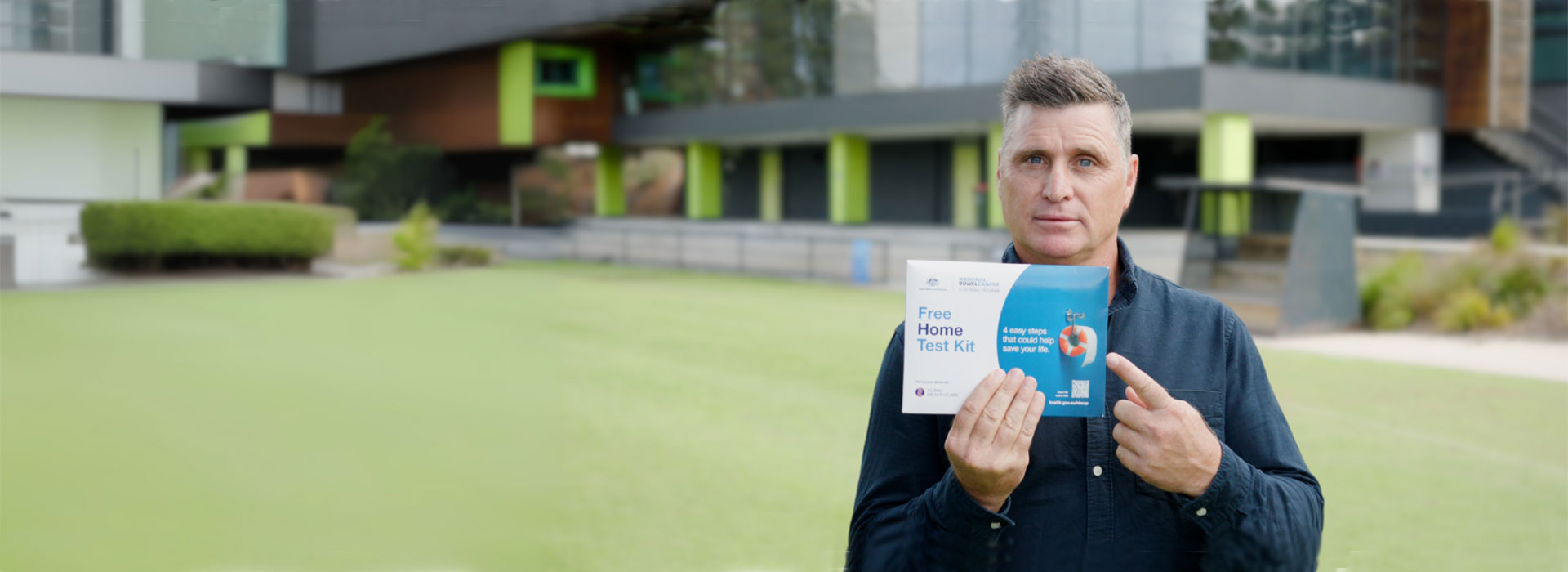 Man pointing at home bowel testing kit