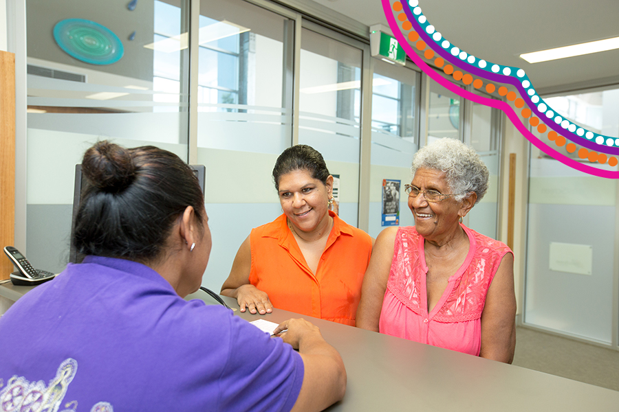 Two Aboriginal and Torres Strait Islander women standing at counter being served by a third woman
