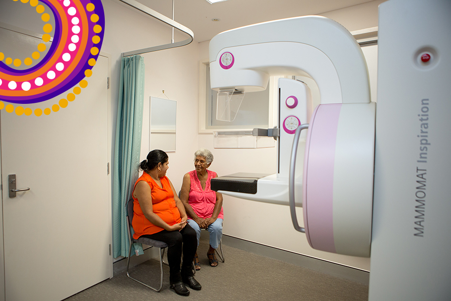 Two Aboriginal and Torres Strait Islander women seated near breast xray device, talking