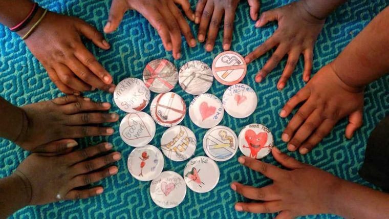 Several Aboriginal and Torres Strait Islander hands reach for some playing tiles