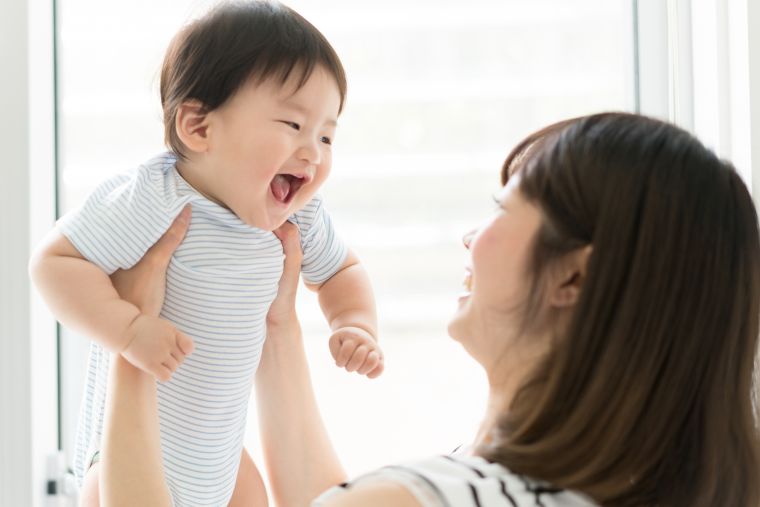 mother holding up baby
