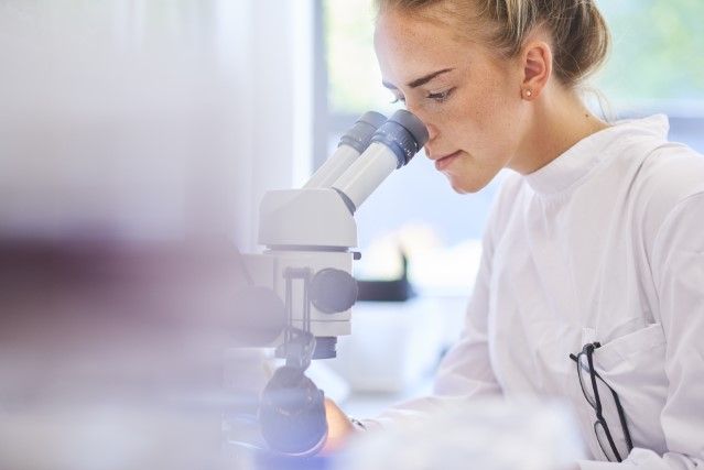 Female researcher with microscope