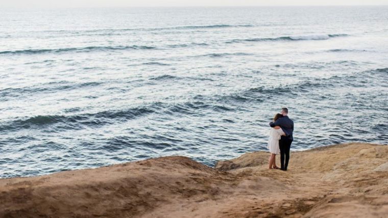 Couple embracing by ocean