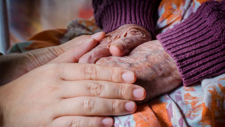 photo of young hands over old hands