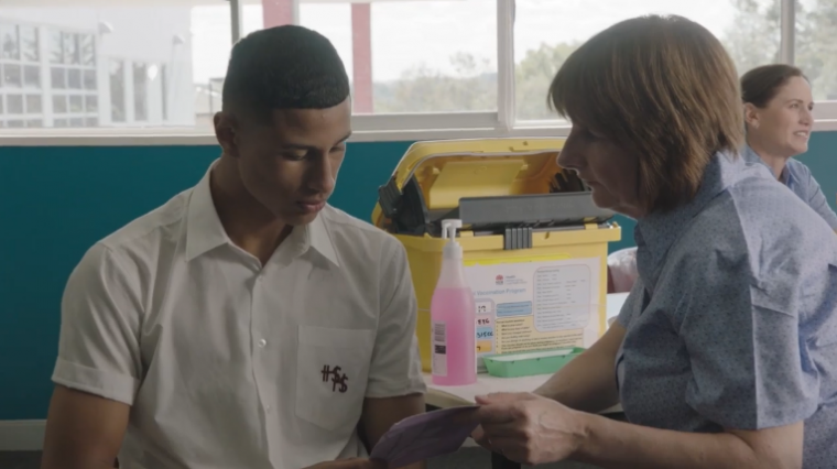 Image of male student and nurse providing vaccination