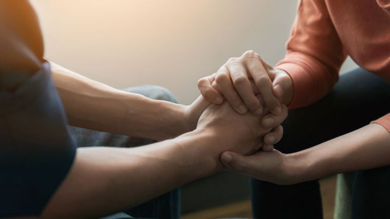 Two people hold hands