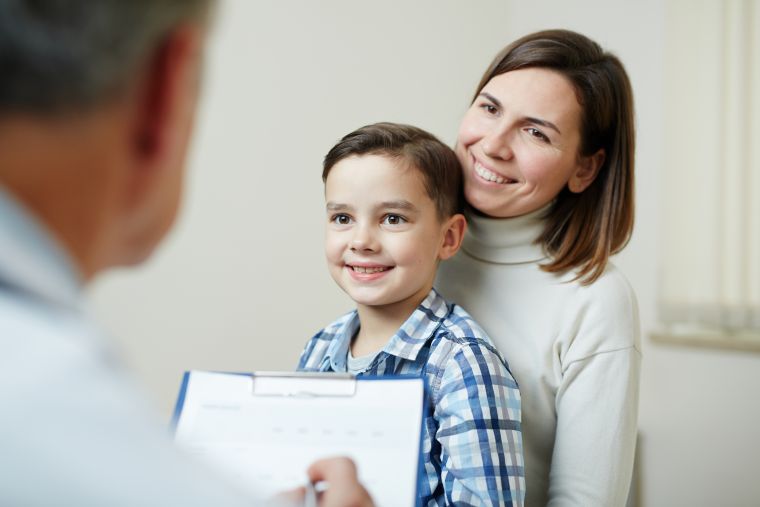 Mother with young son on lap and doctor