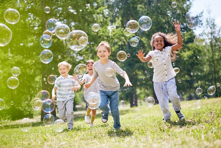 Children running through bubbles