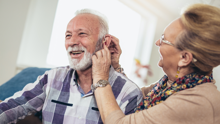 Elderly man being fitted for a hearing aid