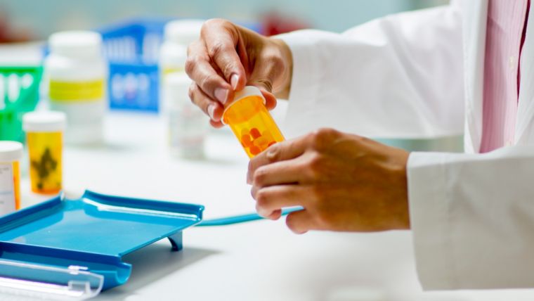Pharmacist filling a bottle of tablets Pharmacist filling a bottle of tablets