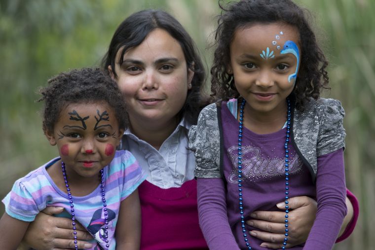 Photo of young woman and 2 young children with their faces painted