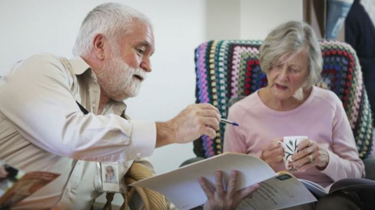 Photo of an older man and an older woman looking at a document