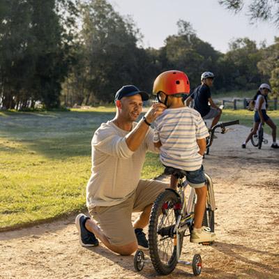 Image of a father teaching his child to ride a bicycle
