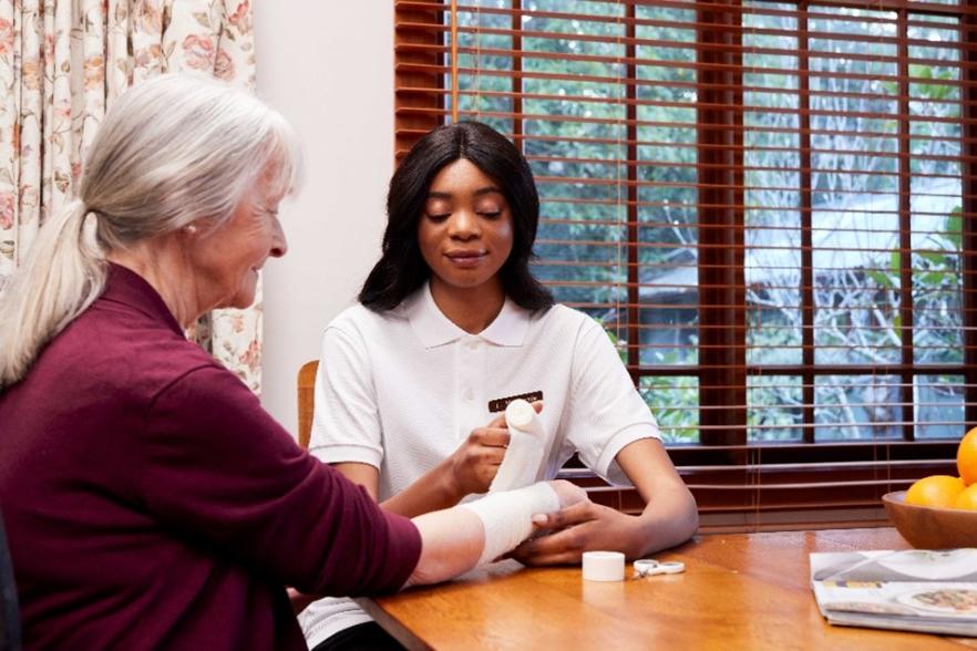 Image of a nurse bandaging an older person's arm