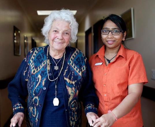 Older person and carer in corridor