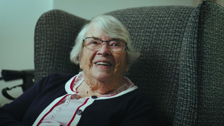 older woman smiling sitting armchair
