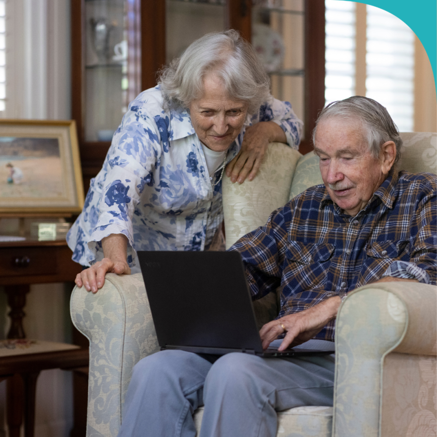 Image of an older woman and older man looking at a laptop