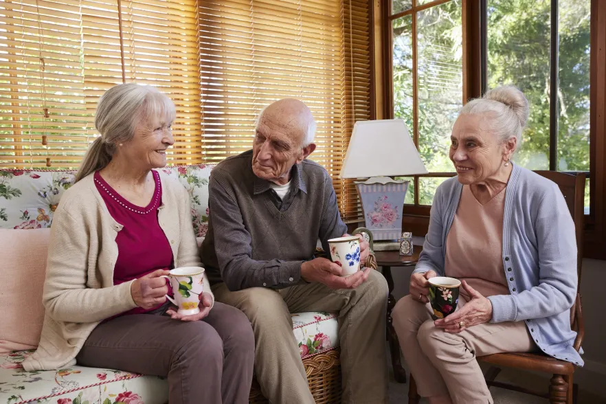 Image of 3 older people having a cuppa