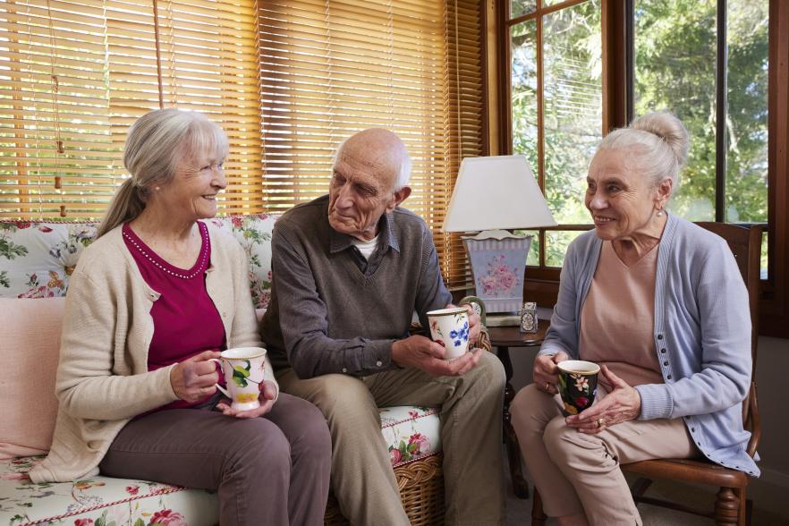 Image of 3 older people having a cuppa