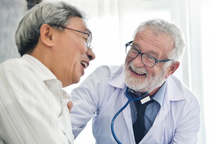 Doctor with male patient laughing