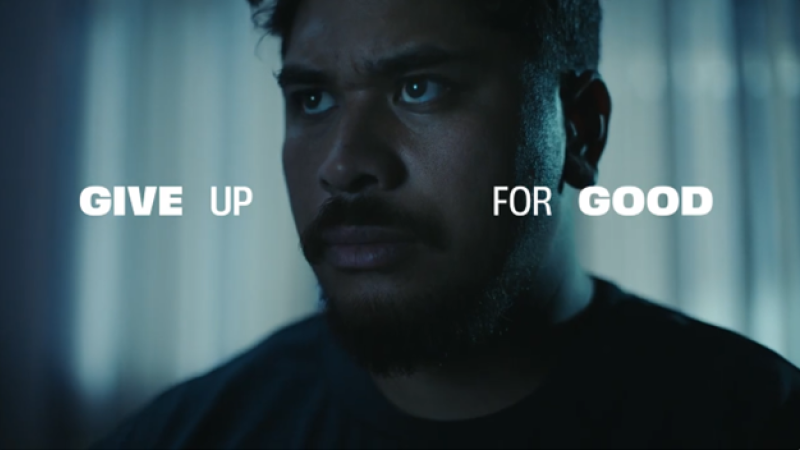 Image of a man in a darkened room with the text - Give up for good overlaid in white