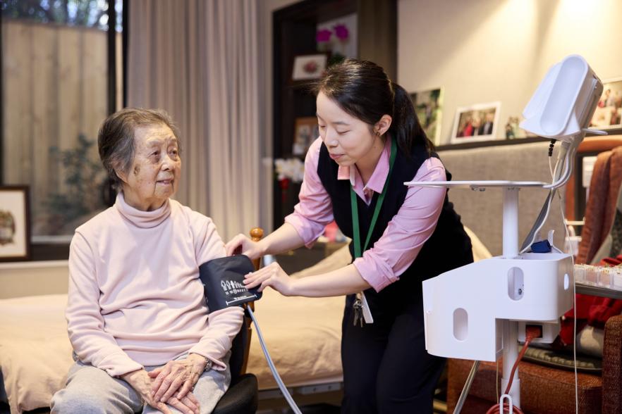 Aged care nurse taking the blood pressure reading of an aged care resident