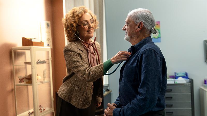 Female doctor using a stethoscope on a male patient