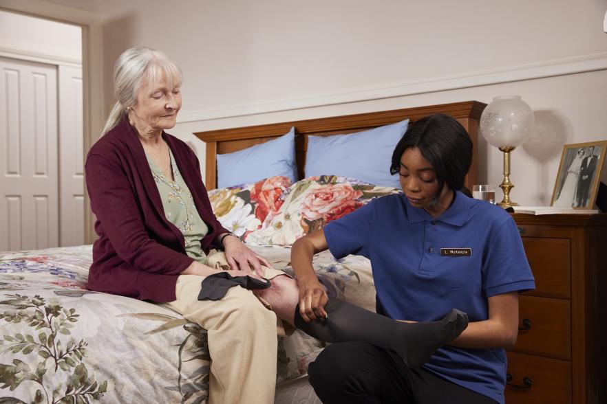 Aged Care Nurse attending female patient