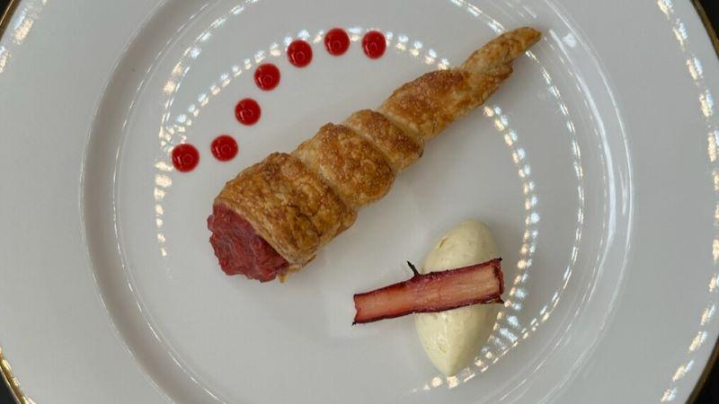 Dessert presented with care at BaptistCare Orana, a pastry with dots of coulis on the plate next to a roll of cream and a piece of rhubarb
