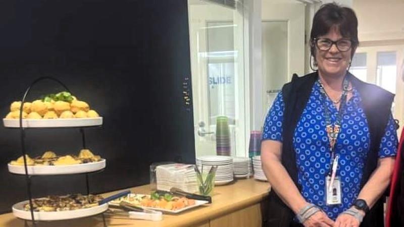 Jenny from Heathcote Health standing next to a tiered stand of food