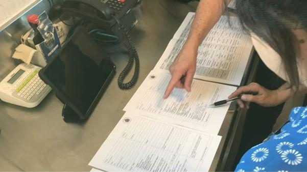 Kitchen staff preparing Heathcote Health’s menus with staff looking closely at paperwork