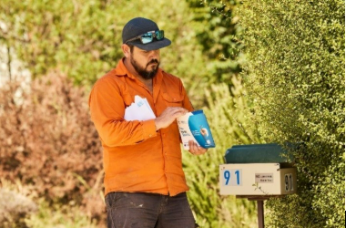 man getting bowel testing kit out of letterbox