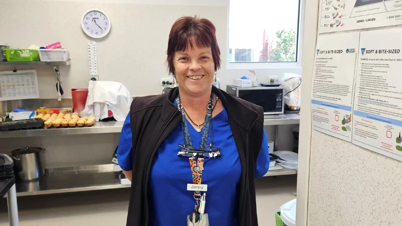 Jenny from Heathcote Health standing next to a tiered stand of food
