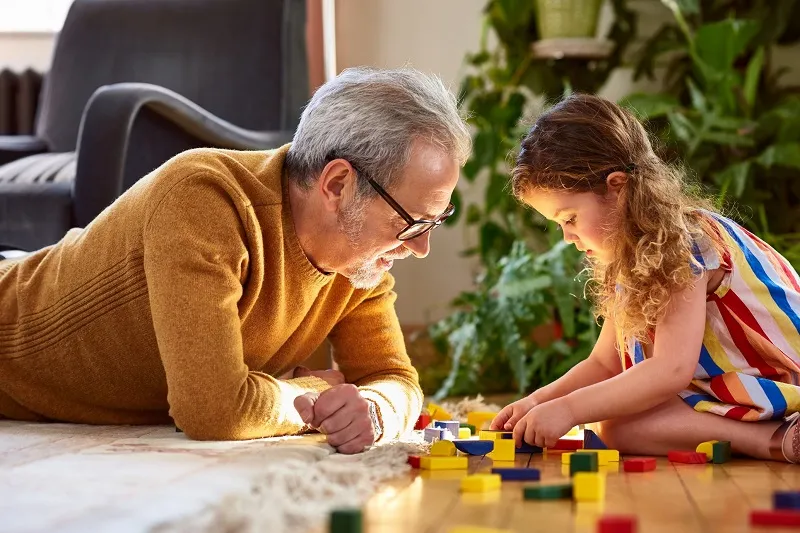 male father with his young daughter playing with blocks