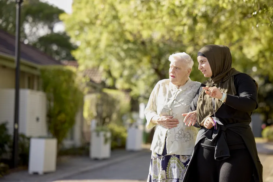 Female Resident and RN Walking Outside