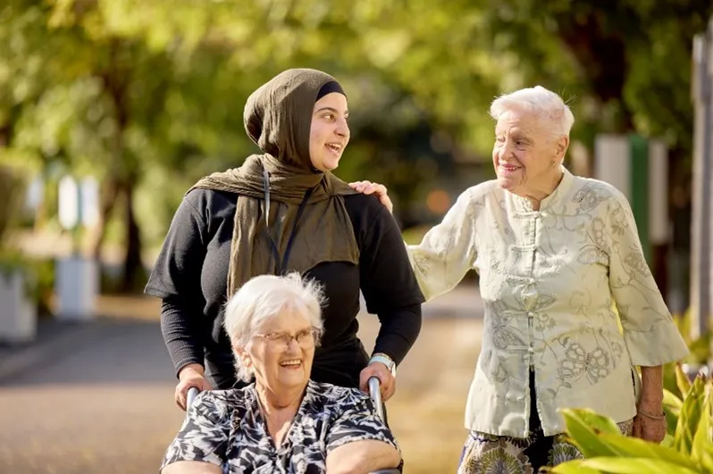 Female Residents and RN walking outside