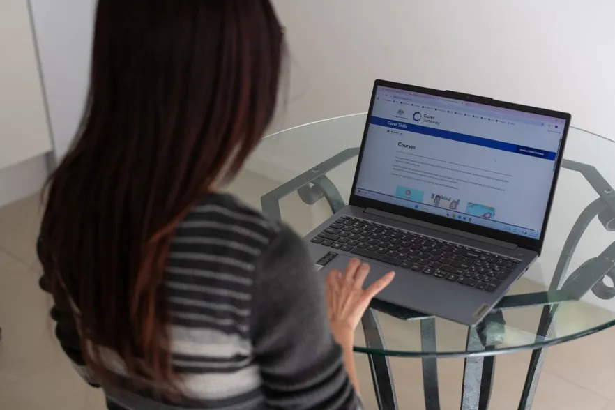 Leanne is a Carers looking at her laptop for Carers Gateway