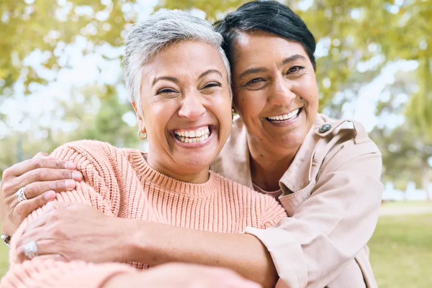 Two people embracing with trees in the background