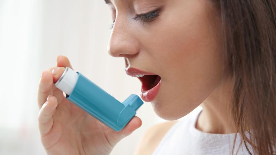 woman uses asthma puffer