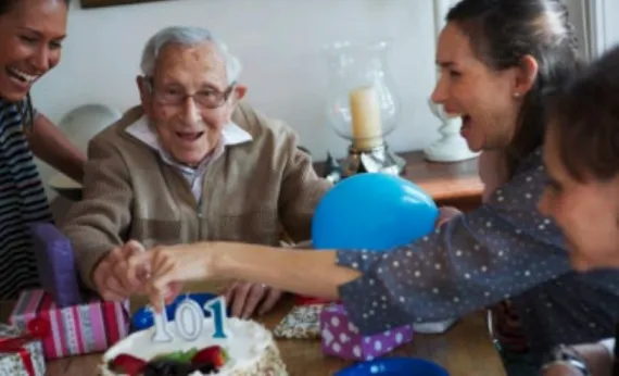 Grandfather surrounded by his family around the table
