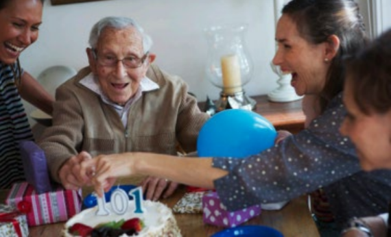 Grandfather surrounded by his family around the table