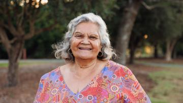 Aboriginal woman smiling standing in a park