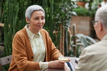Image of an older woman and older man sitting and chatting