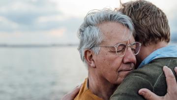 Cover image of 2 people hugging near a body of water