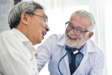 Doctor with male patient laughing