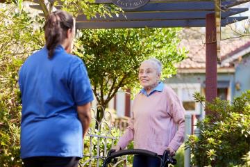 Health care provider with older lady using a walker