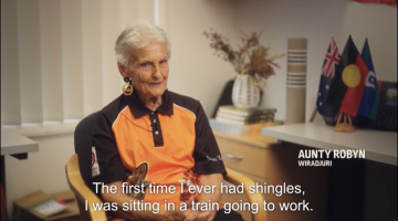 Elderly women sitting in a chair talking about her experience with shingles