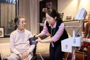 Aged care nurse taking the blood pressure reading of an aged care resident