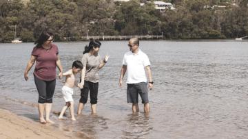 Family without shoes on walking on the edge of a shallow lake – image credit Royal Life Saving Society Australia